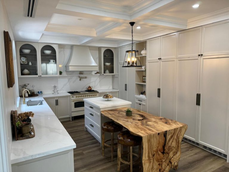 Kitchen with a live-edge timber slab waterfall island, arched glass cabinets and full-height pantry wall by Wondrous Kitchen & Bathroom.